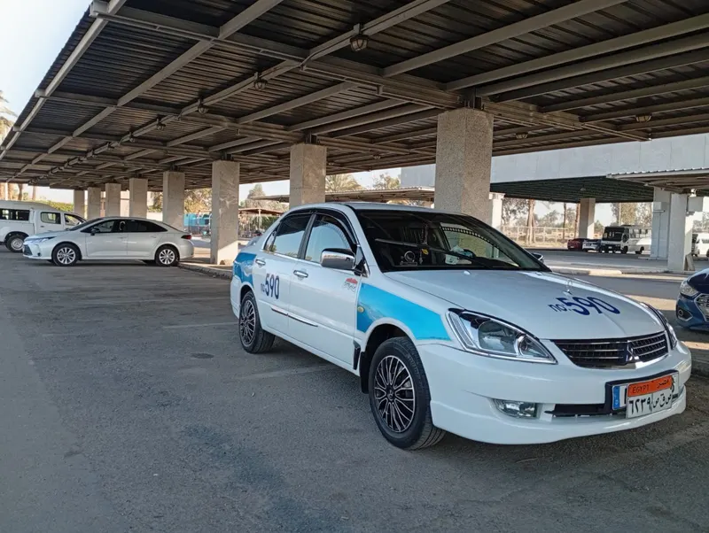 White and blue Mitsubishi Lancer taxi