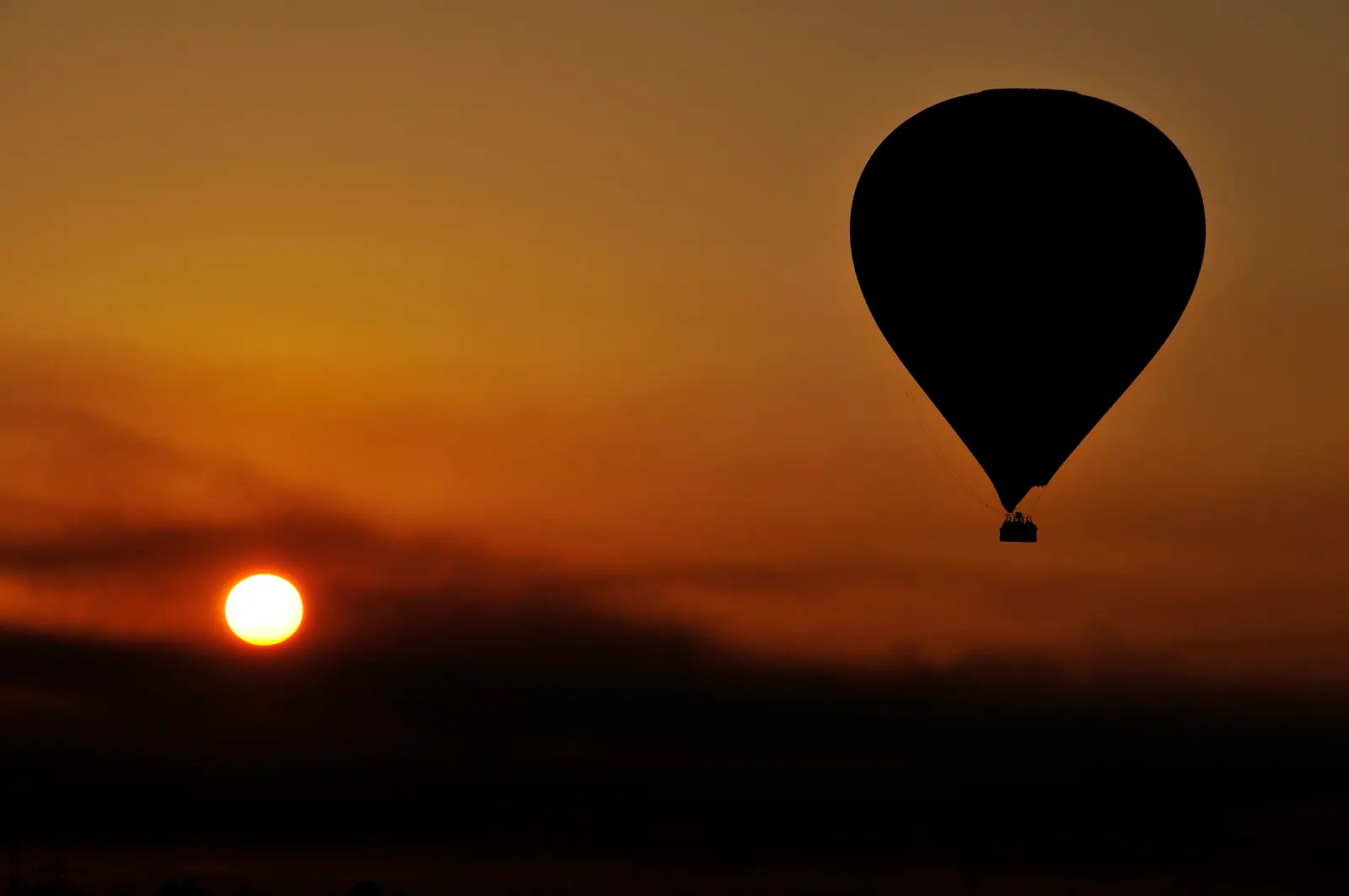 A hot air balloon against the sunrise over Luxor