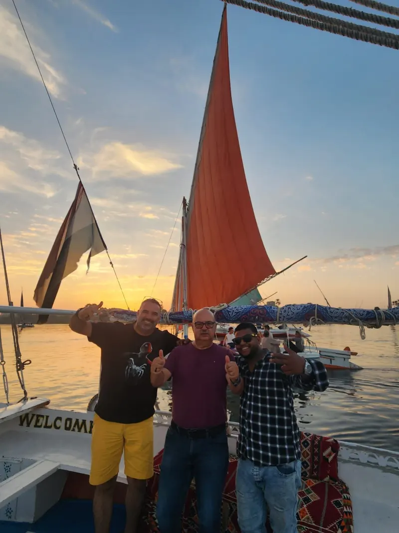 Guests on a felucca with a red sail